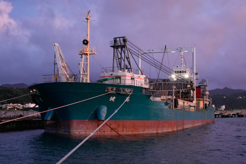 Cargo ship docked at port terminal during twilight
