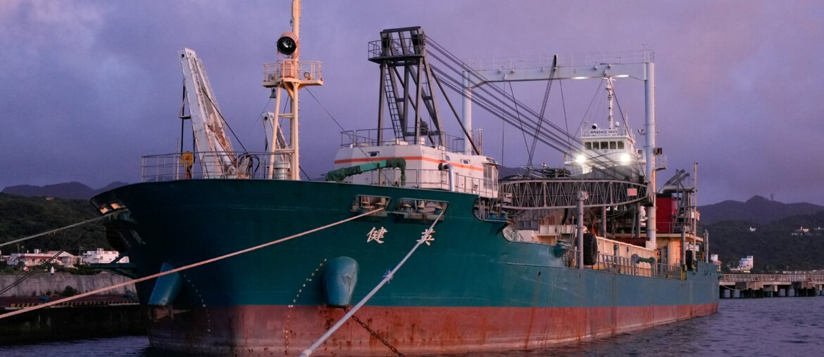 Cargo ship docked at port terminal during twilight