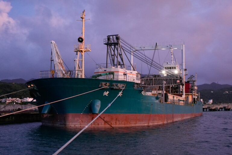 Cargo ship docked at port terminal during twilight