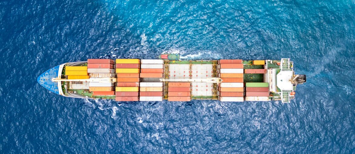Aerial view of a container cargo ship sailing across open ocean