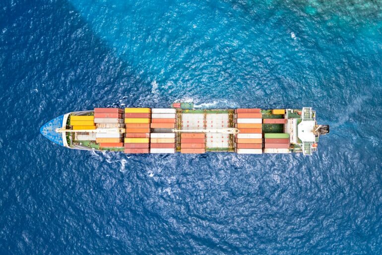 Aerial view of a container cargo ship sailing across open ocean